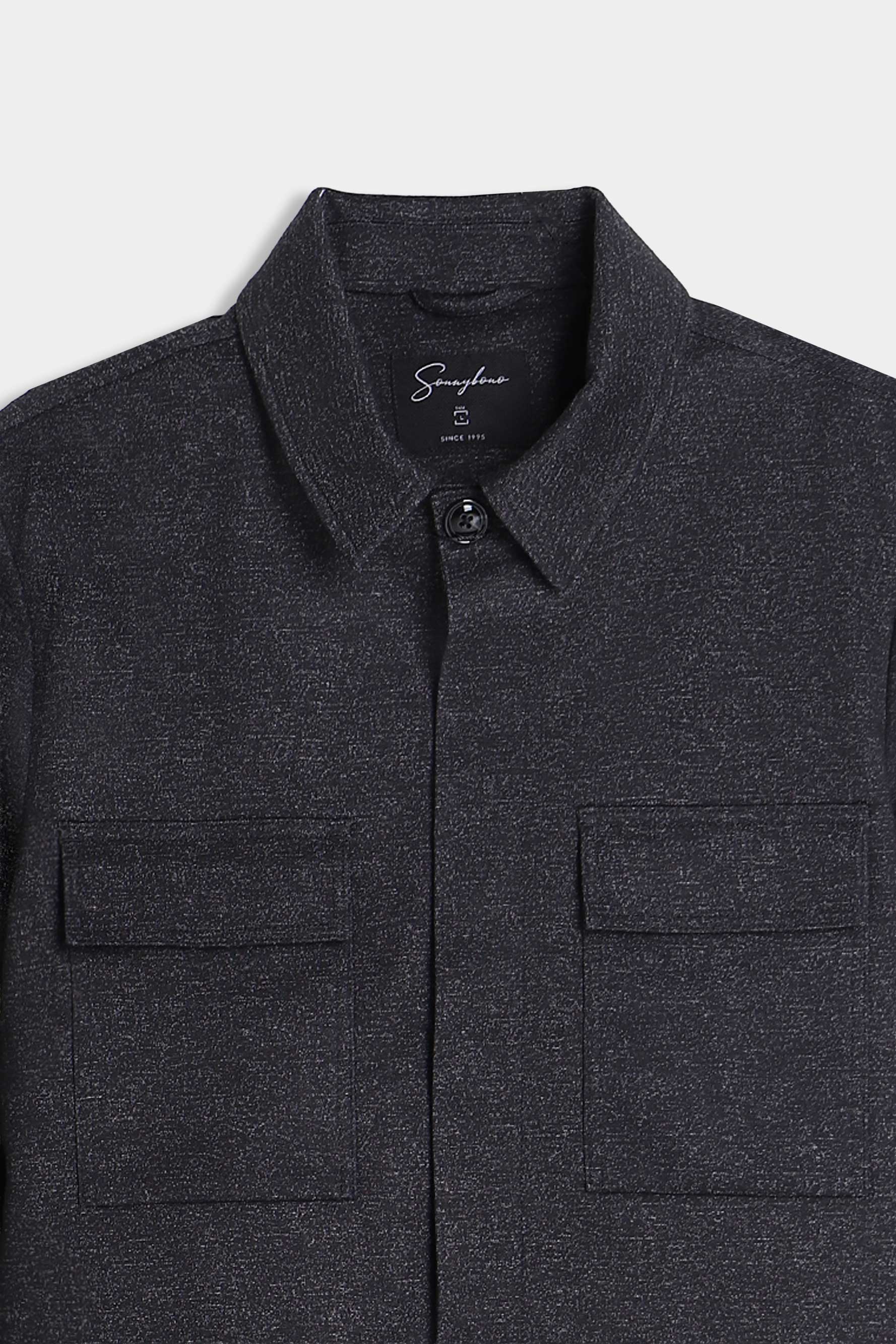 Dettaglio delle tasche frontali dell'overshirt uomo nera